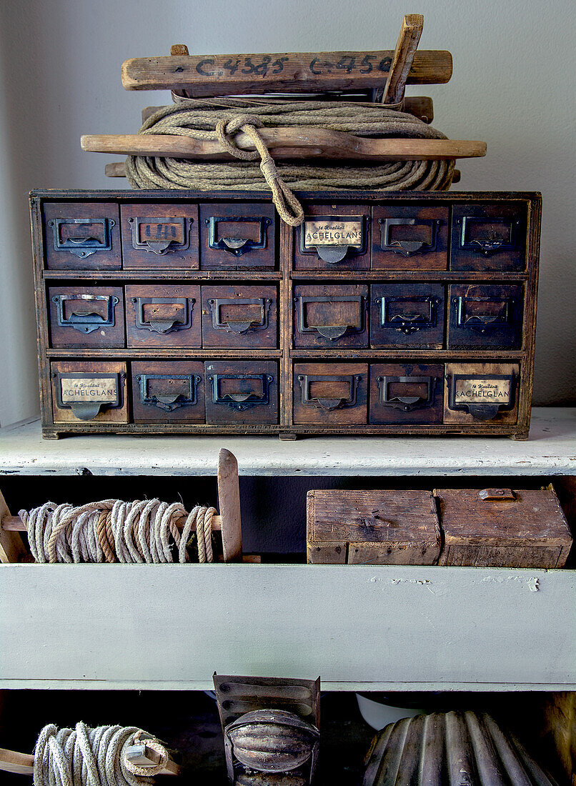 Vintage drawer unit and spools of yarn on a rustic shelf