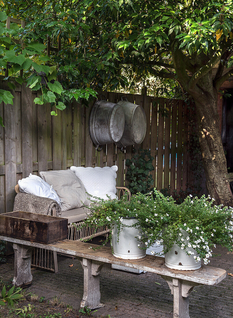 Cosy seating area in the garden with wooden fence as a privacy screen