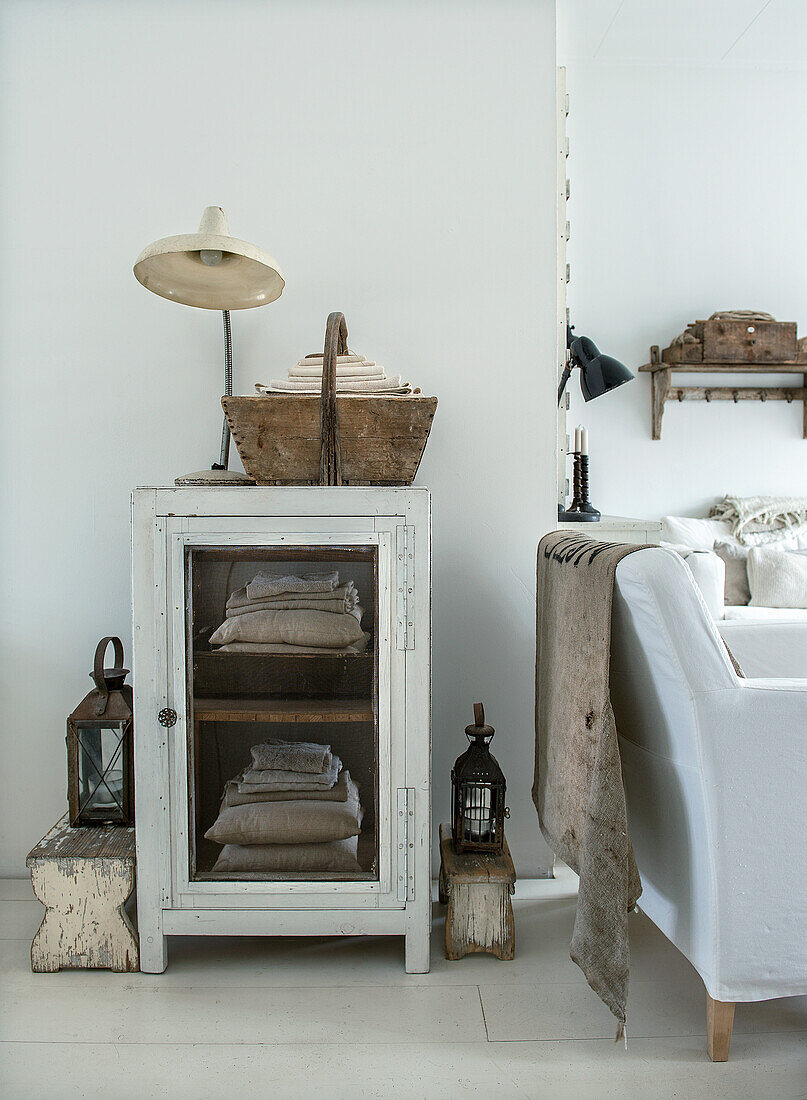 White sideboard with wooden basket and old lamp in the living room