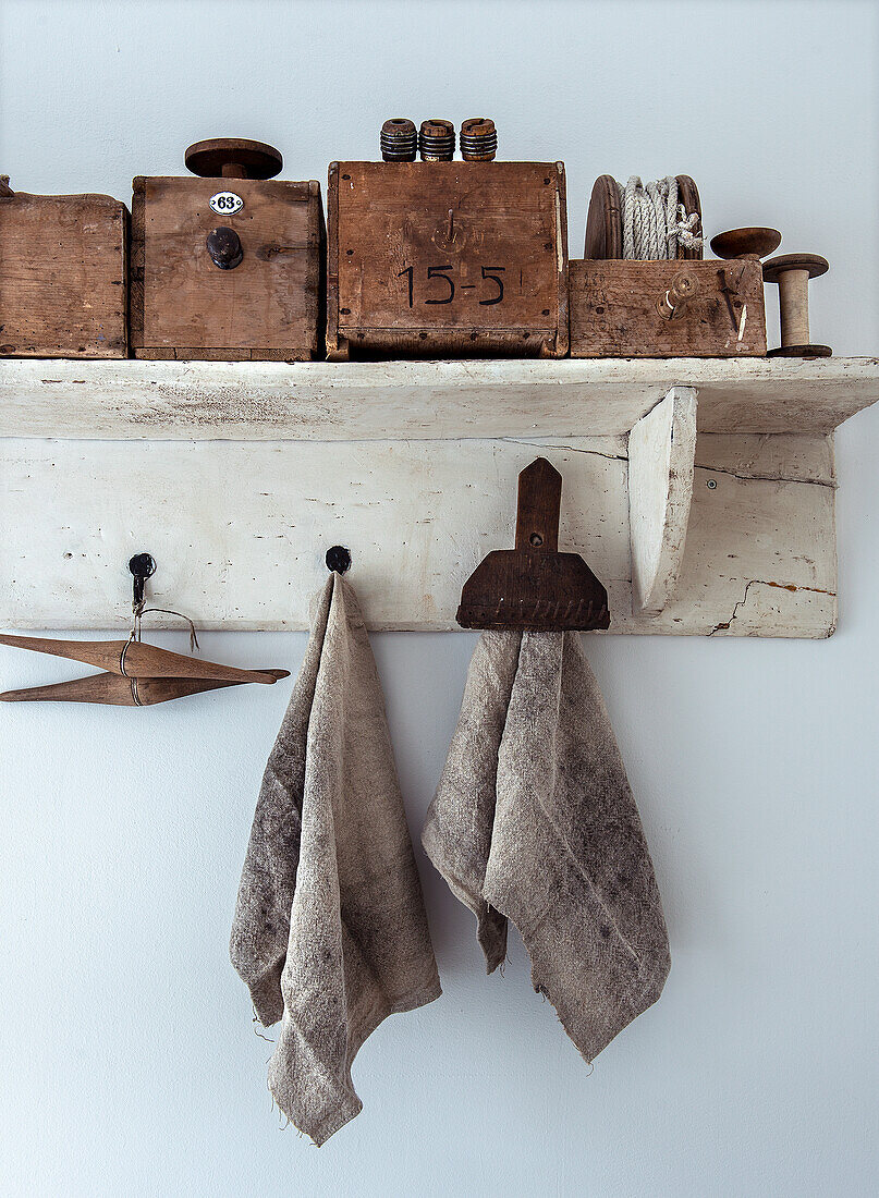 Vintage utensils on a rustic shelf with fabric towels