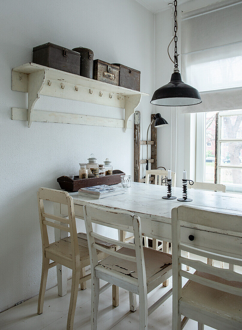 Dining area in shabby chic style with white wooden furniture and vintage lamps