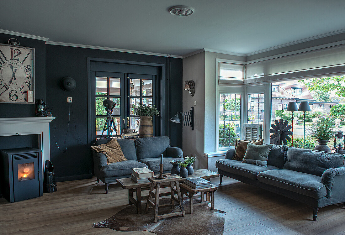 Classic living room with fireplace, grey sofas and wooden side tables