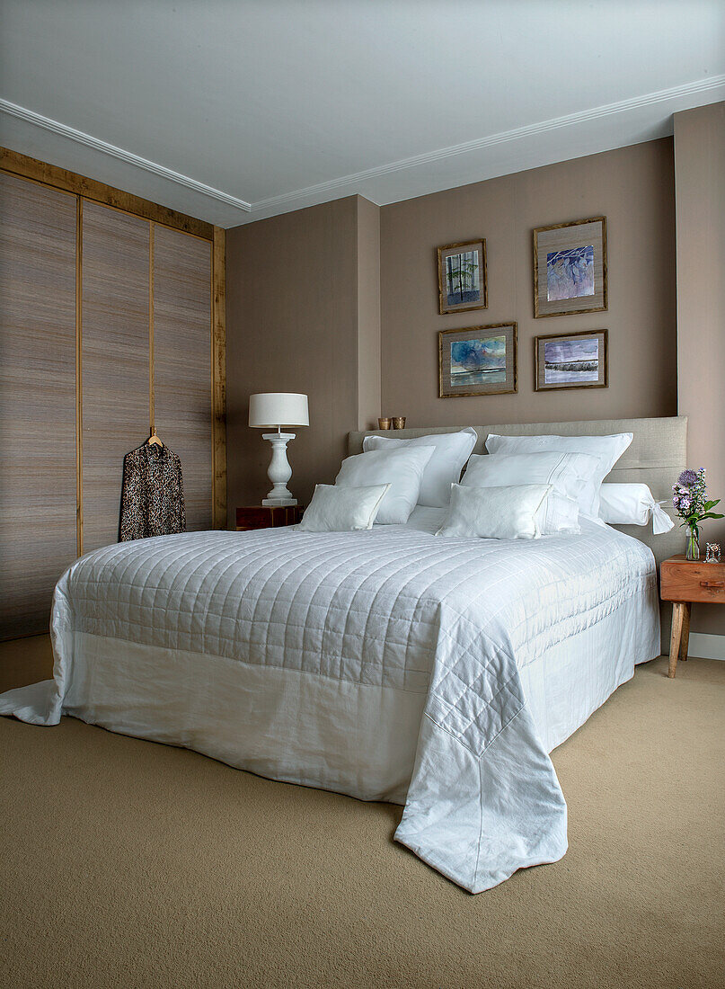 Modern bedroom with white bedspread and built-in wardrobe