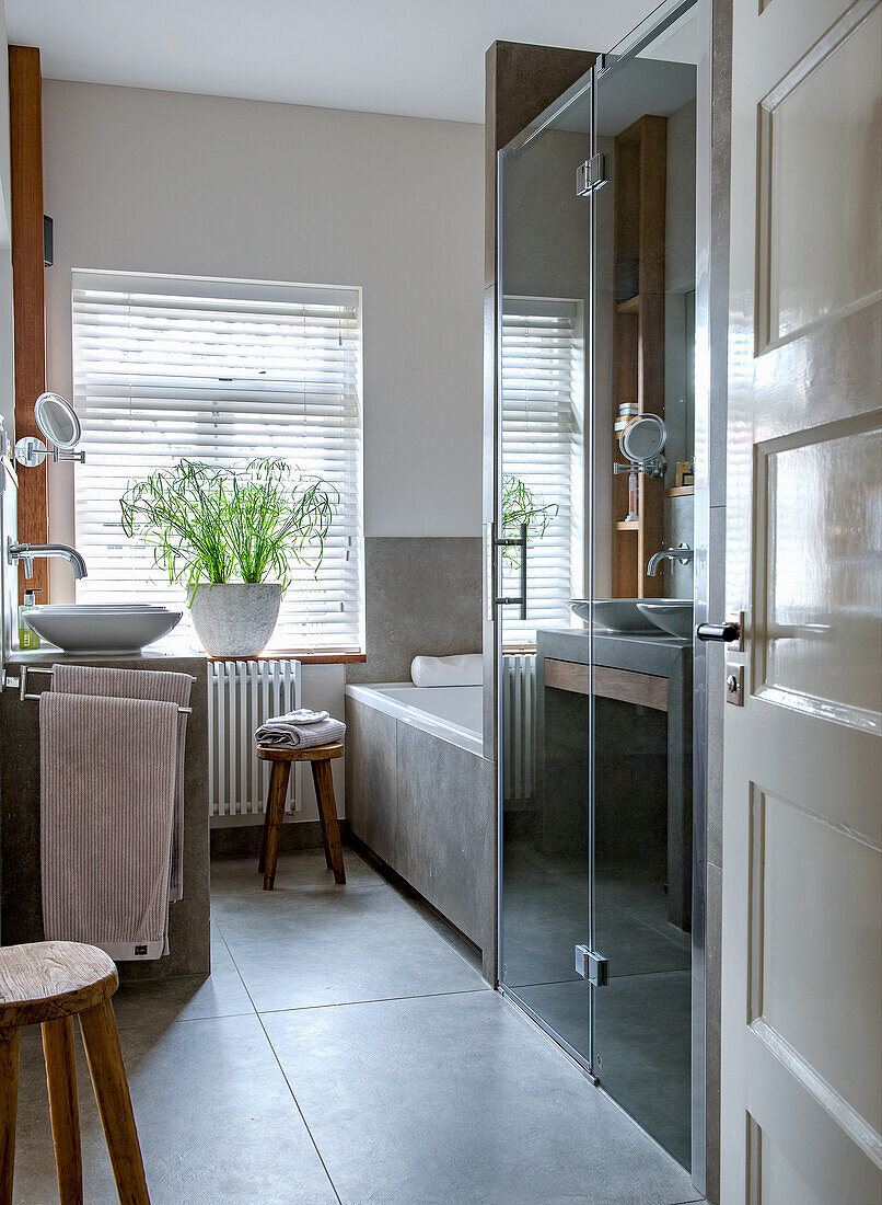 Modern bathroom with light grey tiles and glass shower