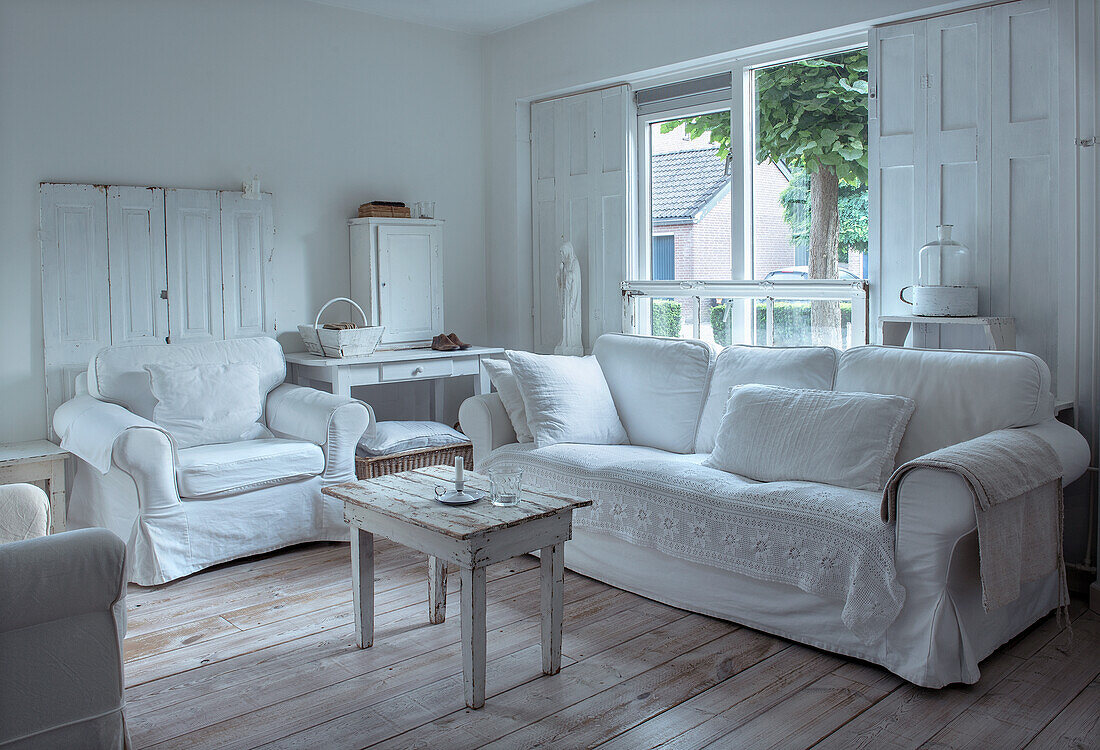 Living room with white furniture and wooden floor in shabby chic style