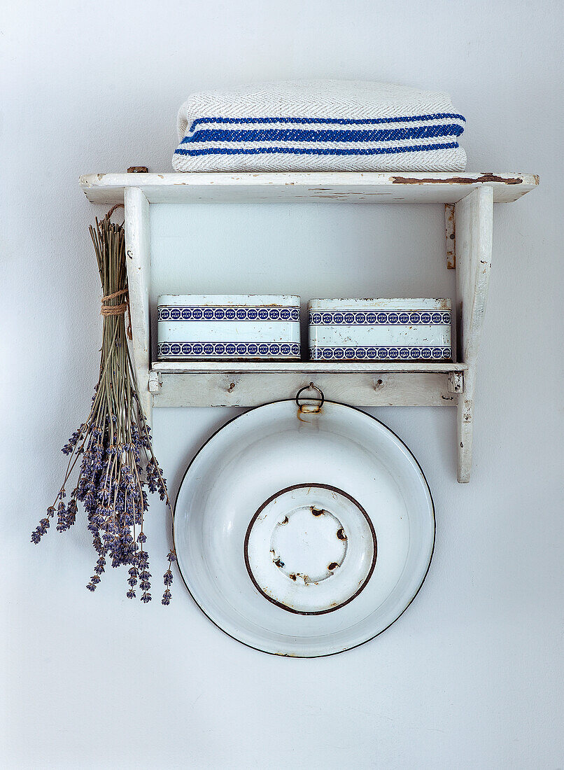 Rustic wall shelf with lavender bundle, enamel plate and towels