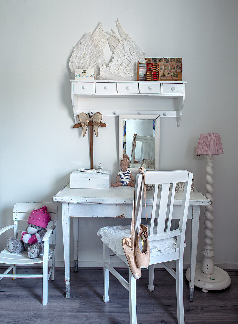 White children's desk with wing decoration and pink lampshade