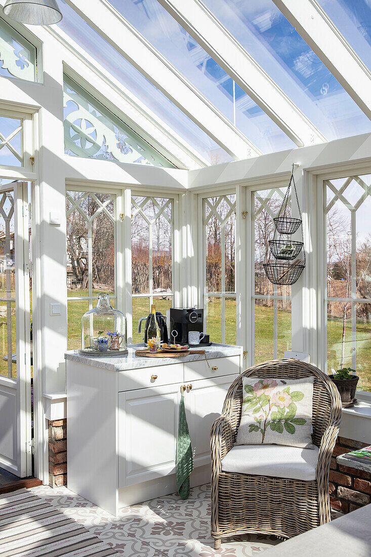 Conservatory with rattan armchairs and small kitchenette