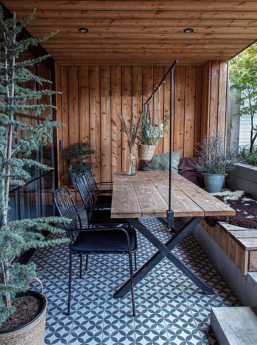 Covered patio with wooden wall and patterned tiled floor