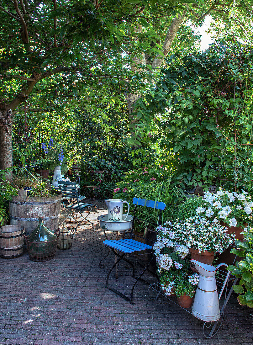 Idyllischer Gartenbereich mit blühenden Pflanzen und Sitzgelegenheiten