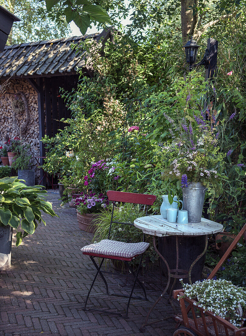 Cozy seating area in the garden with metal furniture and flower vases