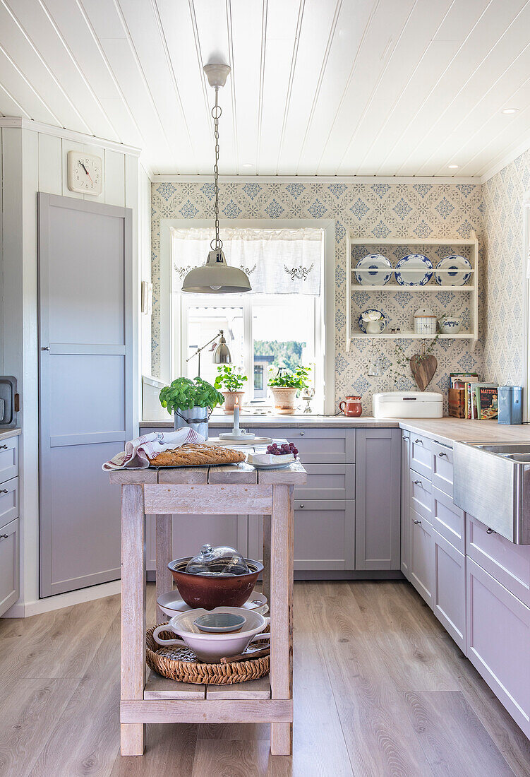 Bright country kitchen with kitchen island and blue-patterned wallpaper