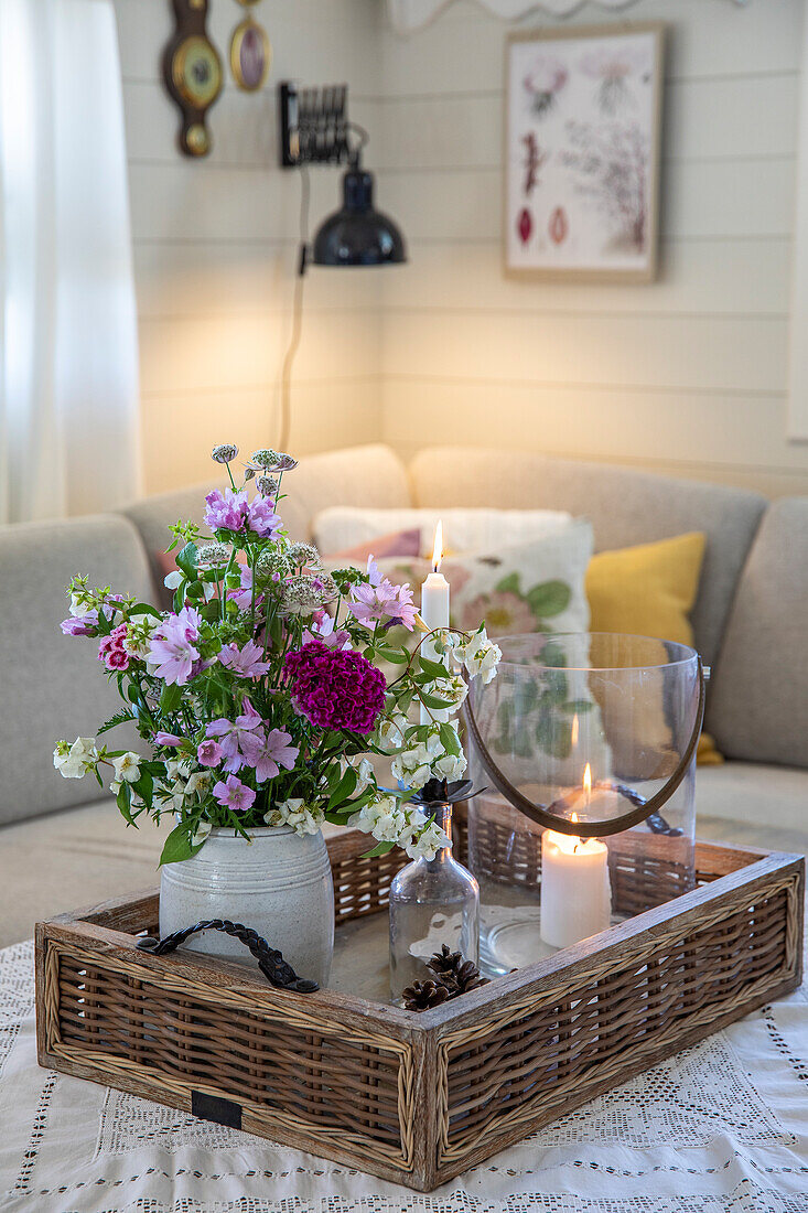 Bouquet of flowers and candles on a tray in the cosy living room