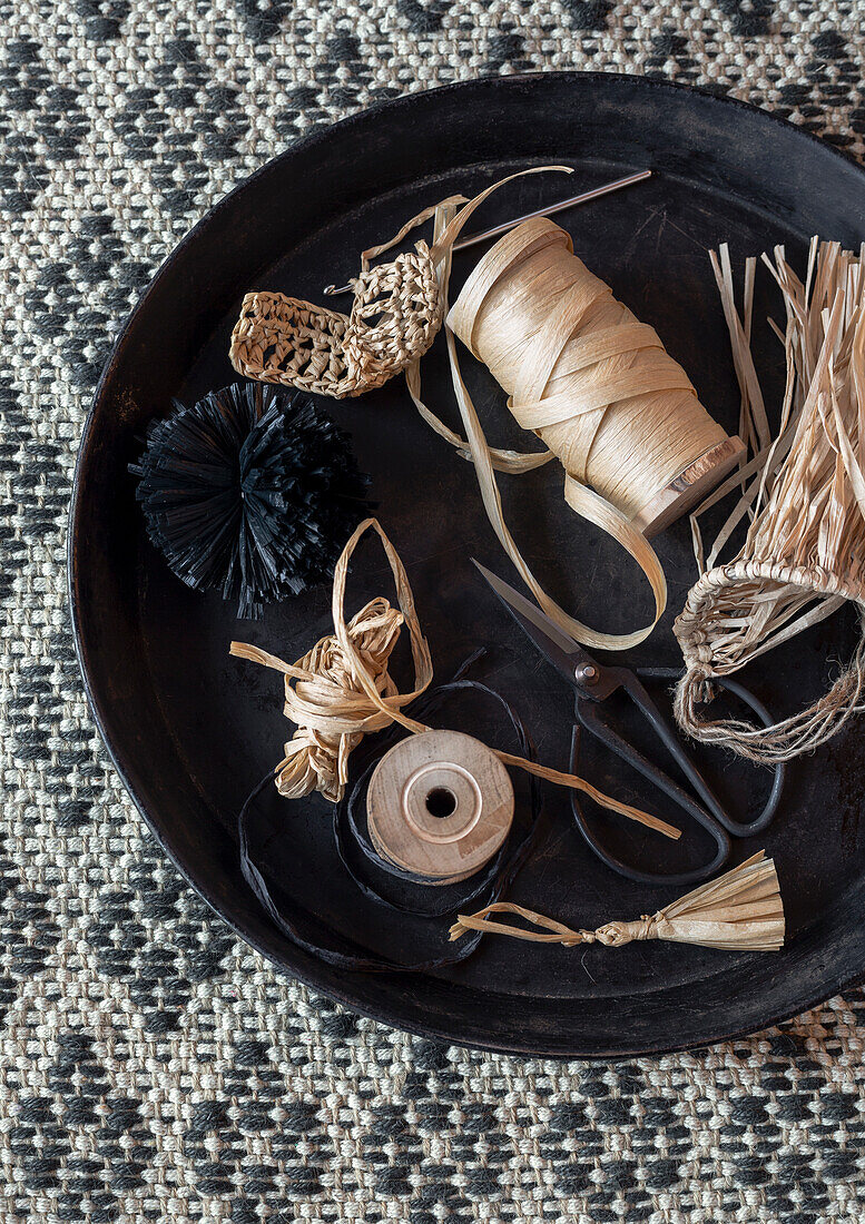 Materials for DIY craft projects on a round metal tray