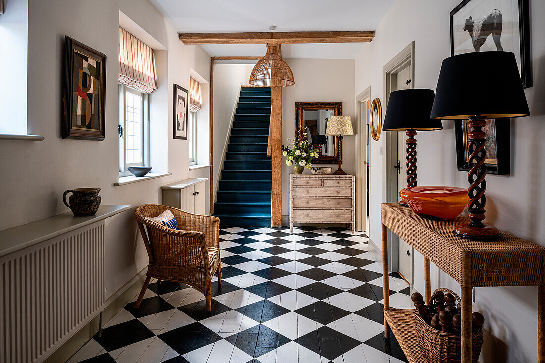 Bright hallway with black and white chequered floor and blue steps