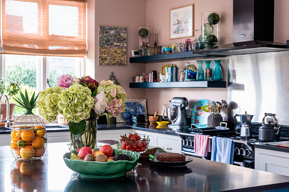 Kitchen with bouquet of flowers and fruit bowl on island