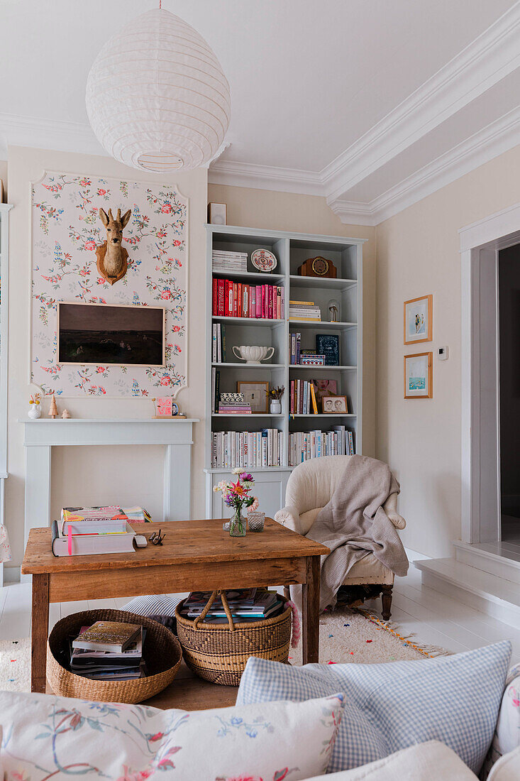 Living room with open wooden shelf, coffee table and floral accents