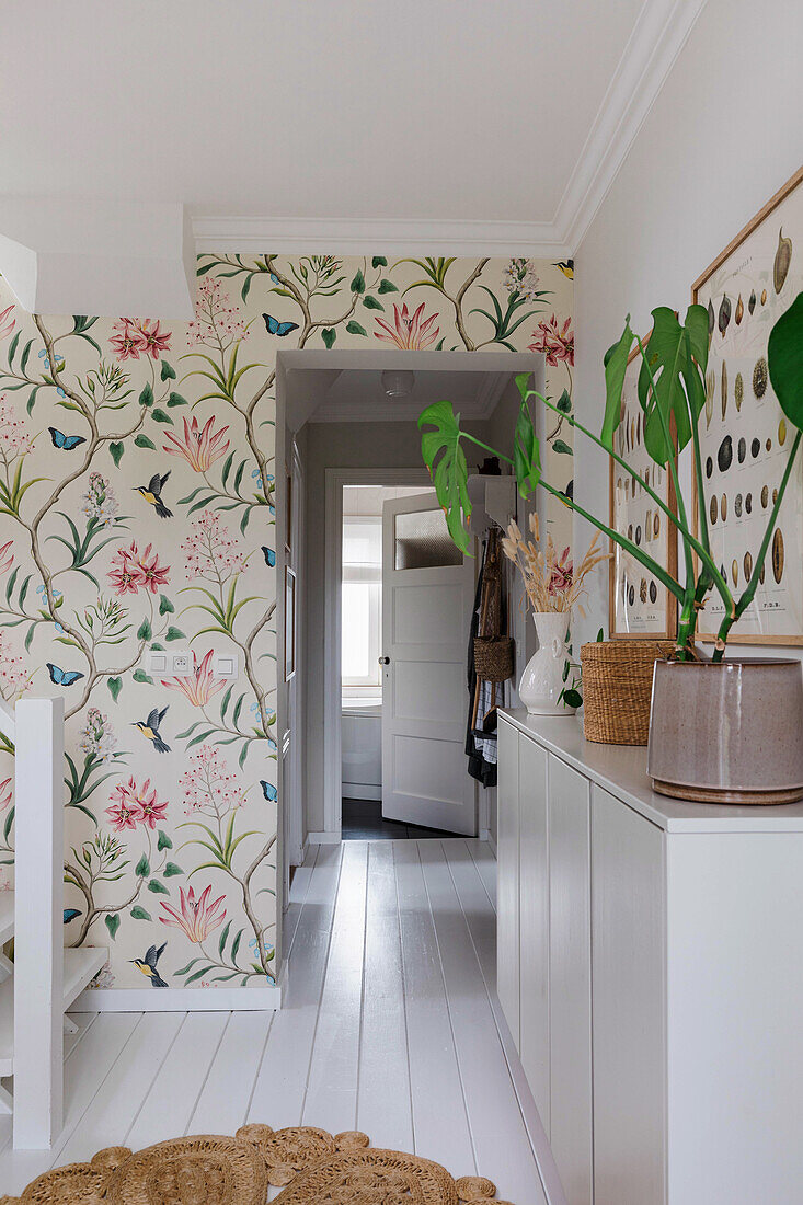 Hallway with floral wallpaper and white-painted wooden floor