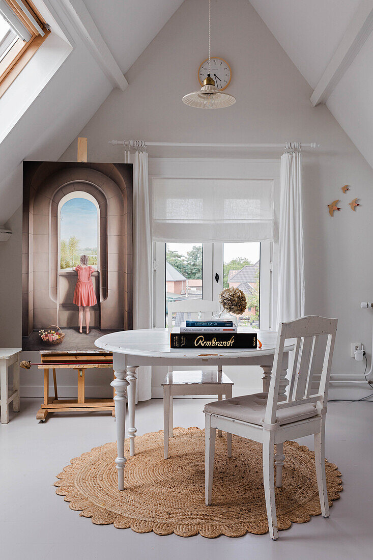 Attic bedroom with easel, round table, chair and sisal carpet