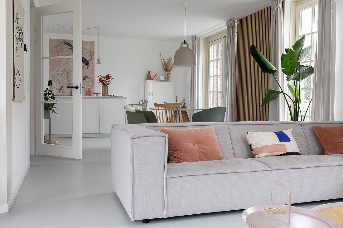 Open-plan living room with grey sofa and dining area in the background