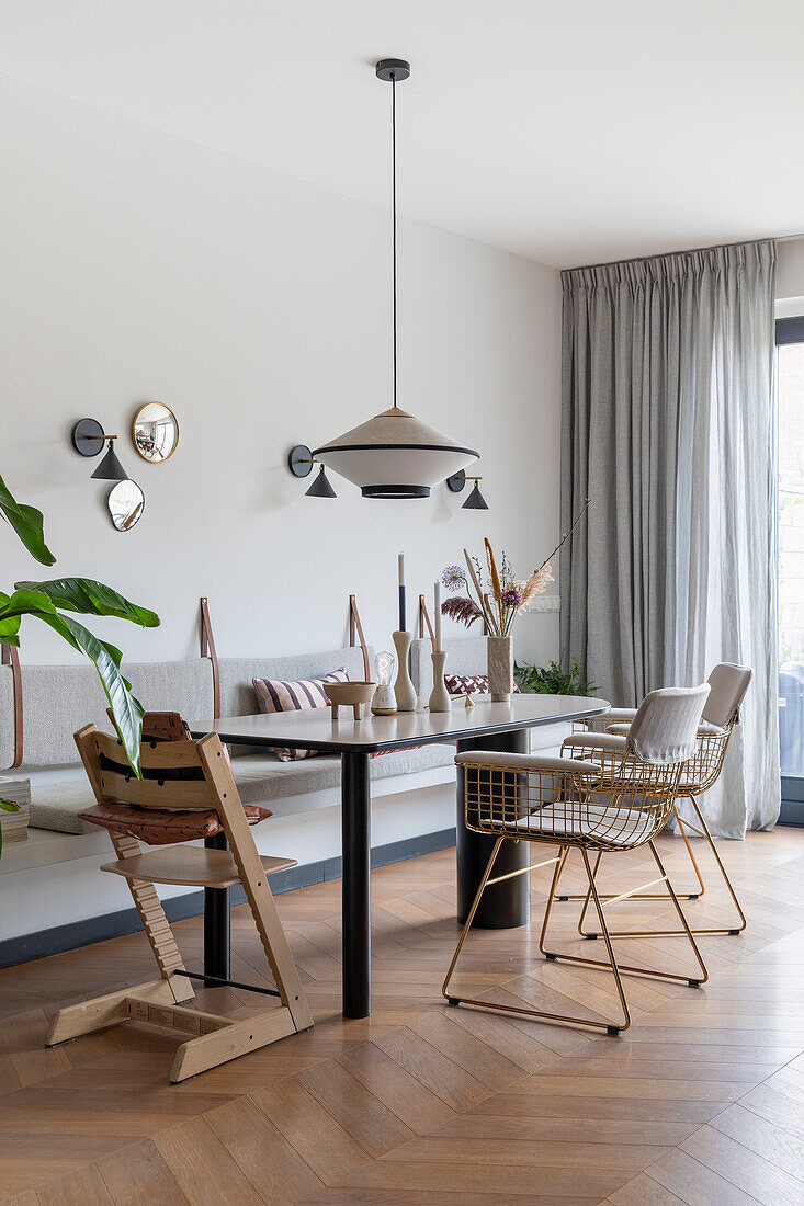 Dining room with metal chairs, modern pendant lamp and wooden floor