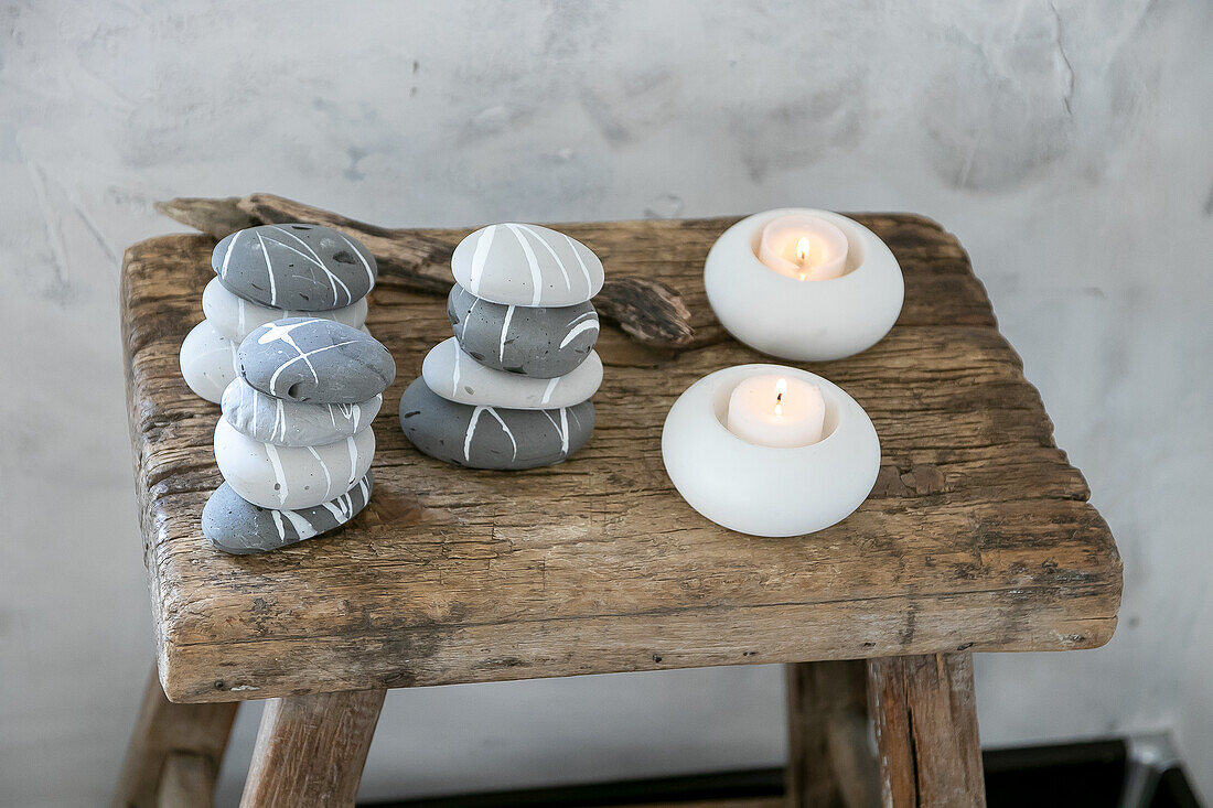 Painted stones and tealight candles on a rustic wooden stool