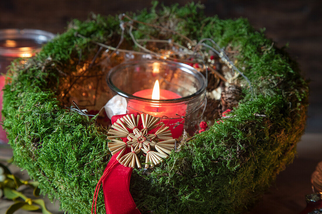 Weihnachtliche Moosdekoration mit Kerzenglas und Strohstern