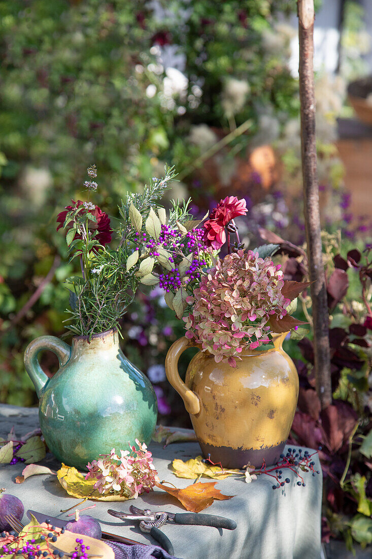 Colourful autumn bouquets in ceramic pots on a garden table