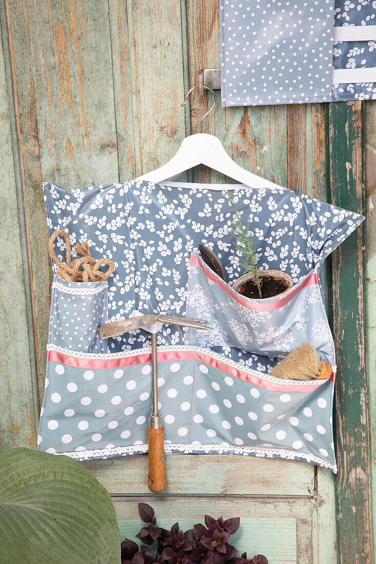 DIY garden apron with pockets and garden tools on old wooden door