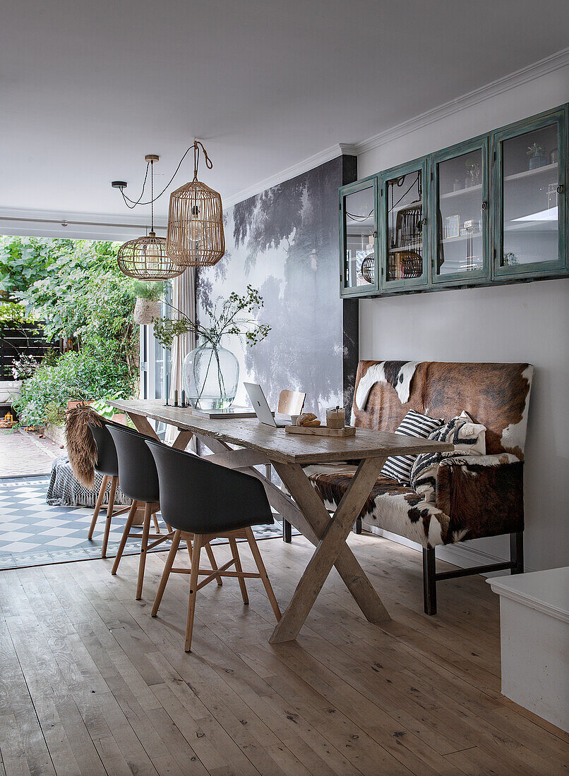 Dining area with wooden ceiling, cowhide bench and rattan hanging lamps