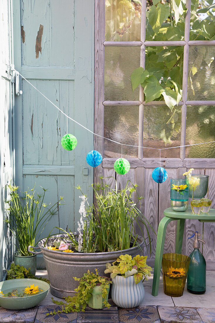 Idyllischer Miniteich mit Pflanzen und Lampions im Außenbereich