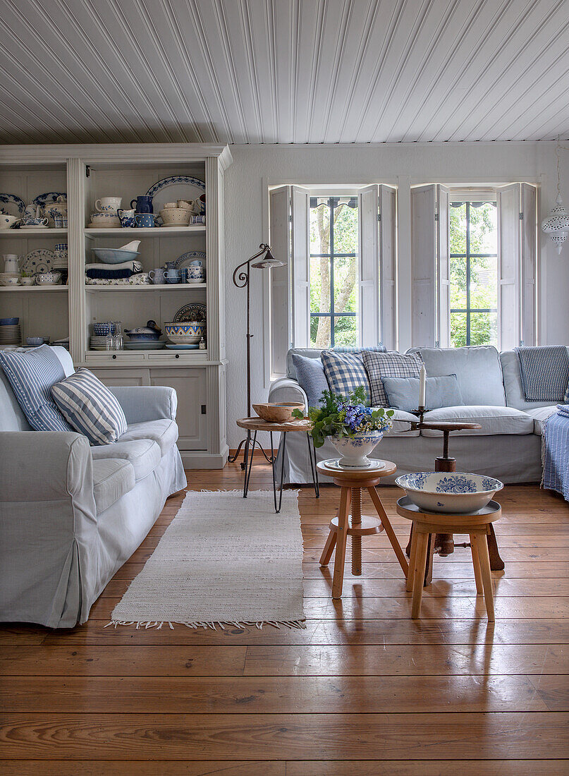 Wohnzimmer im Landhausstil mit Holzboden und hellen Sofas