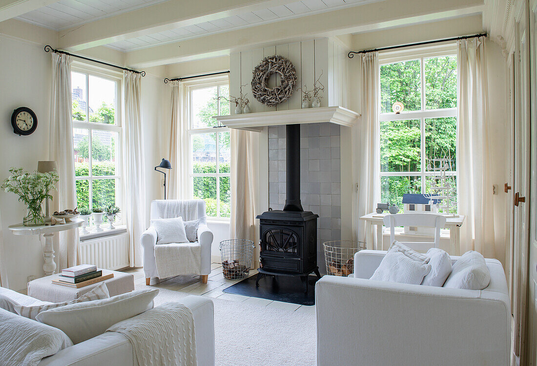 Bright living room with wood-burning stove and large mullioned windows