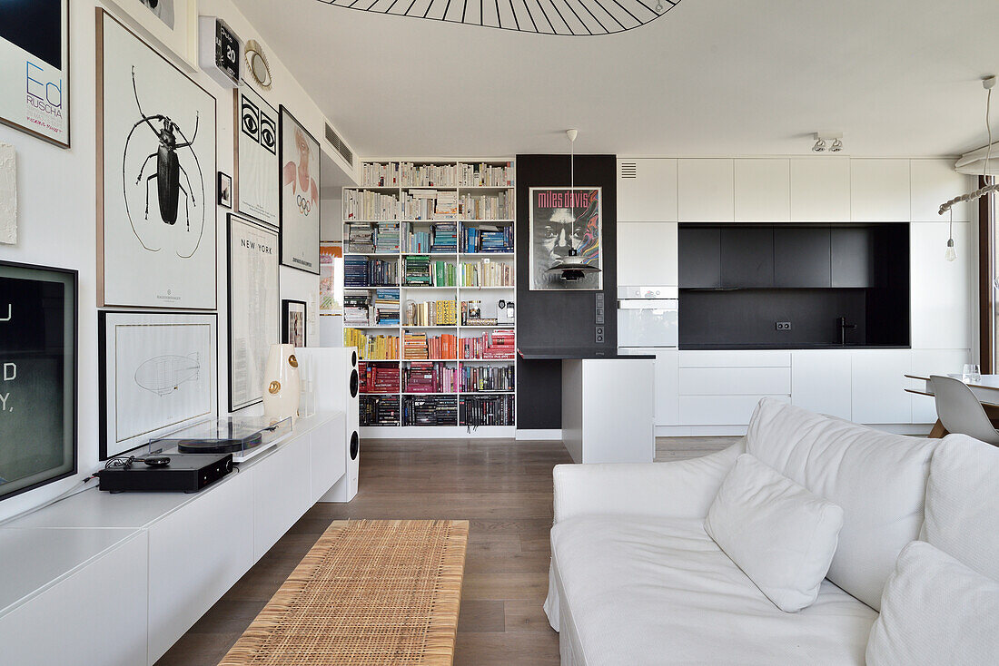 Modern living room with bookshelf, white sofa and wall art