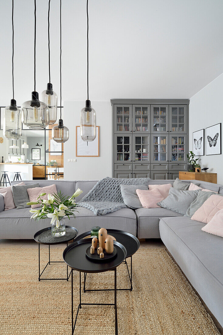 Hell gestaltetes Wohnzimmer mit modernen Möbeln und Pendelleuchten