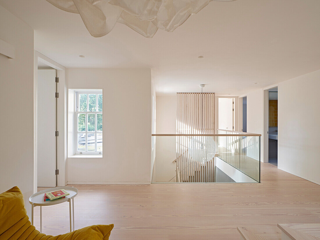 Modern upper floor with glass railings and wooden floor in London