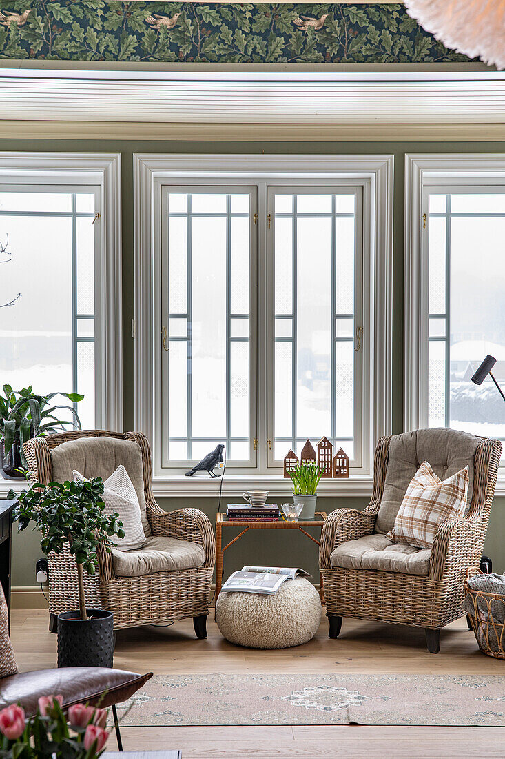 Rattan armchair, side table and pouf by the window