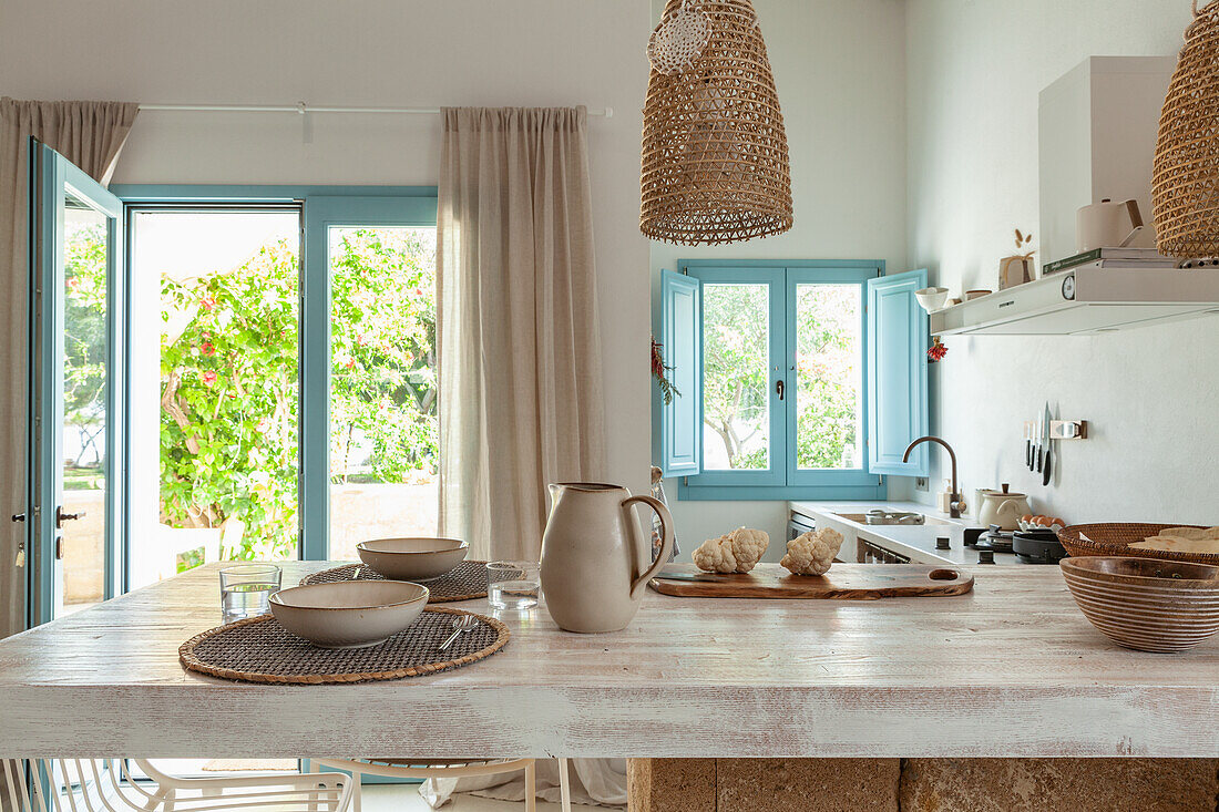 Küche mit Tresen, blauen Fensterläden und Rattanlampen