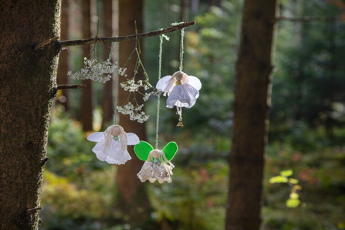 Drei handgefertigte Blütenfeen-Anhänger aus Spitze und Filz im Wald