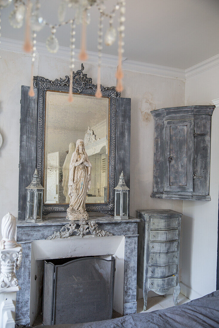 Mantelpiece with antique mirror and sculpture of the Virgin Mary