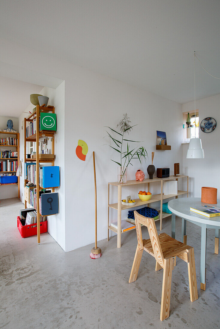 Modern dining area with wooden furniture and bookshelf