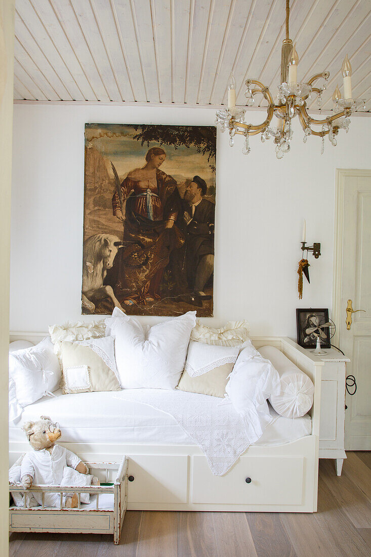 White daybed with cushions and antique painting in the living room