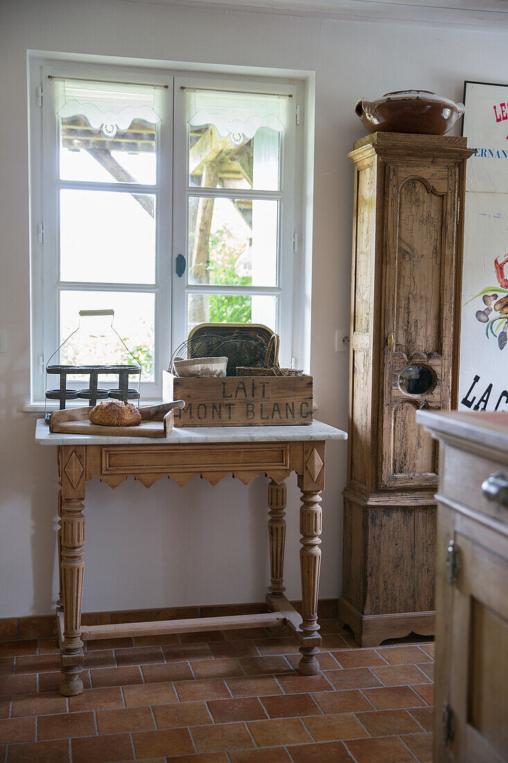 Rustikaler Holztisch mit Vintage-Milchkiste und Brot im Landhausstil-Küchenbereich