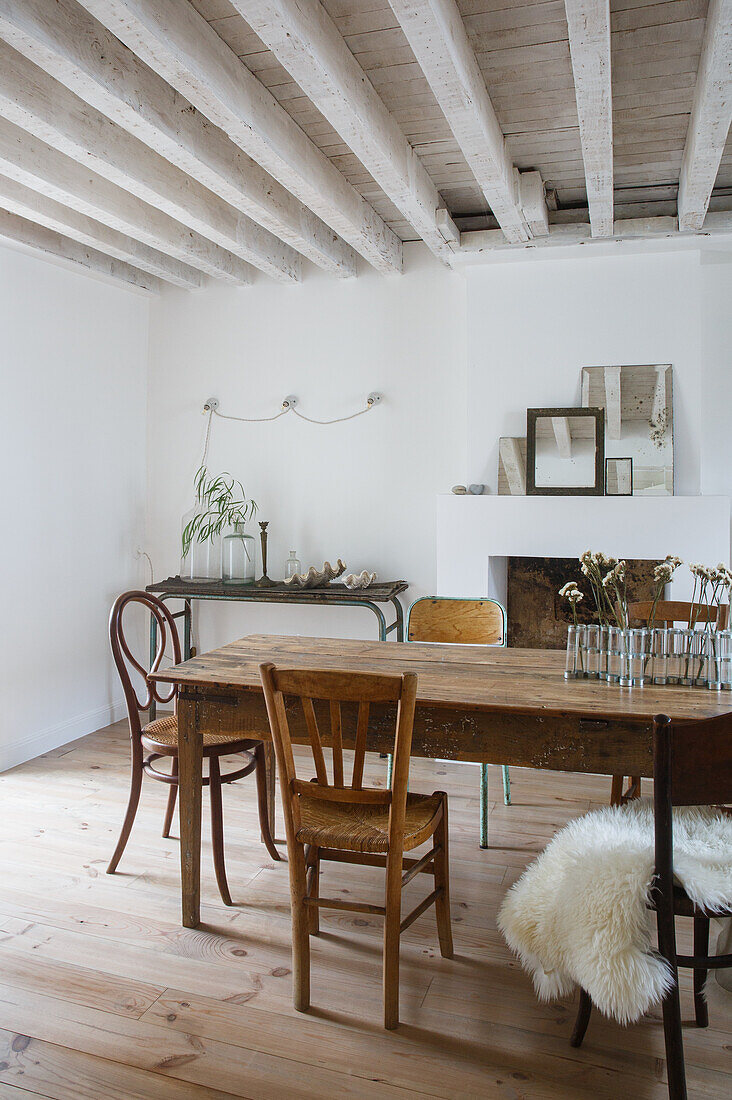 Dining room with rustic wooden table, various wooden chairs and wooden beamed ceiling