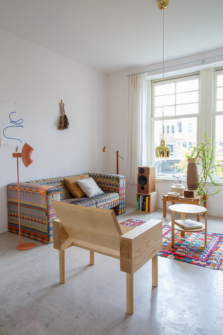 Living room with patterned sofa and light-coloured wooden furniture