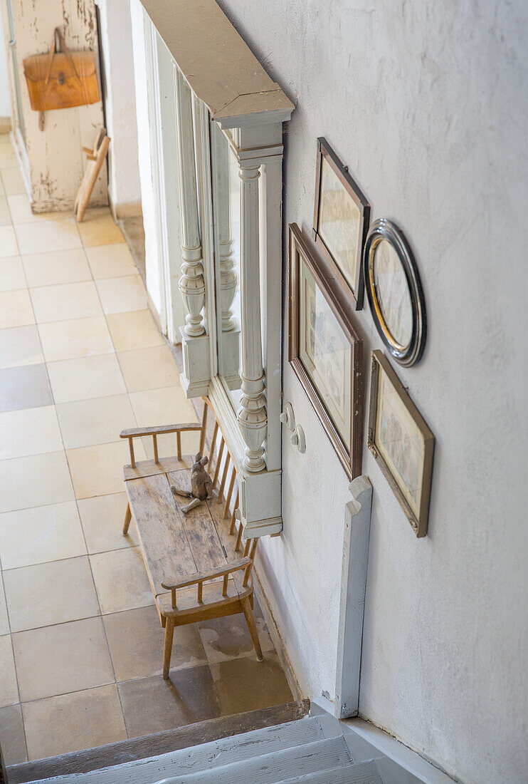 Rustic wooden bench in hallway with wall mirror and pictures