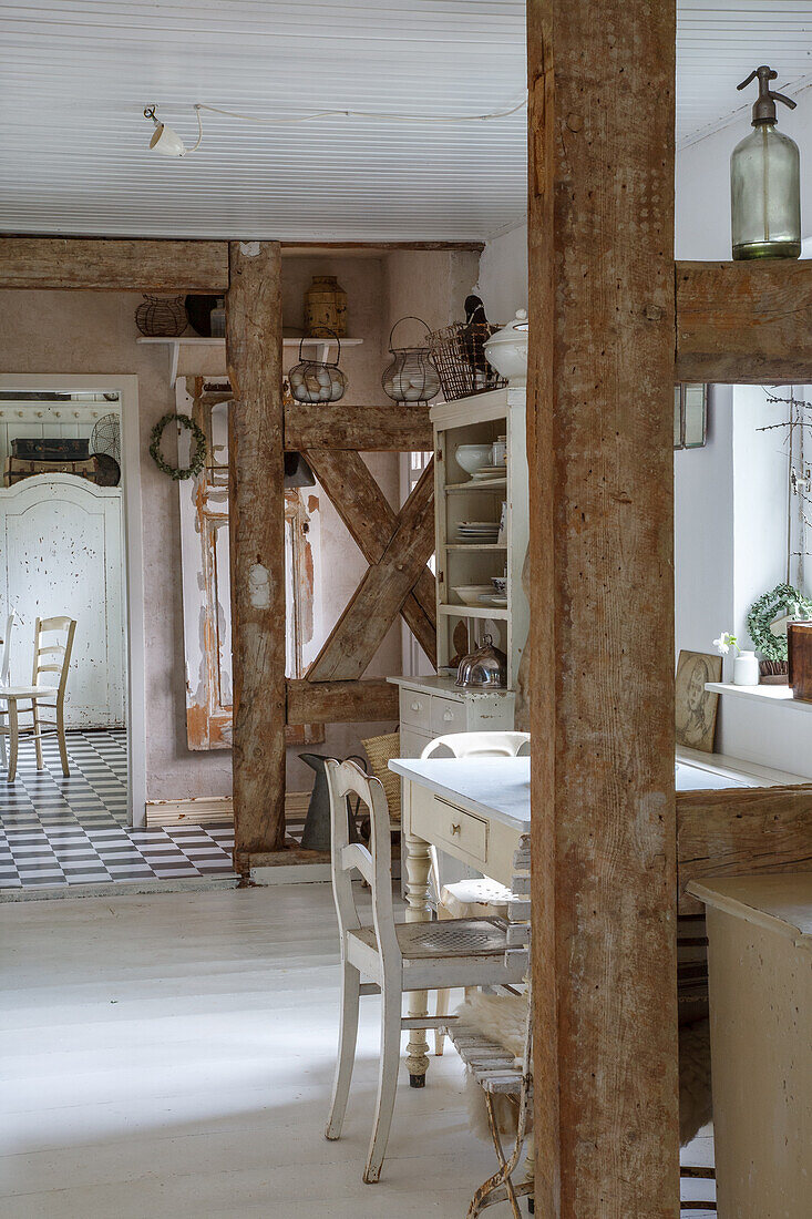 Dining area with white-painted wooden furniture and exposed wooden beams