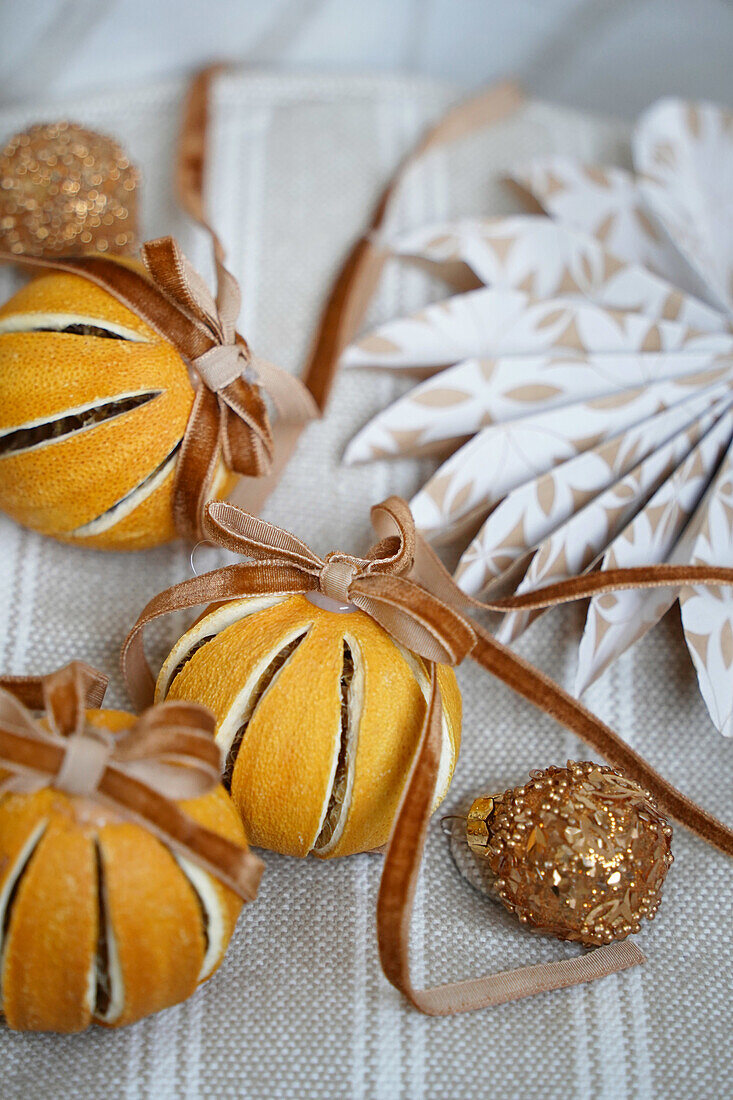 Weihnachtliche Dekoration aus getrockneten Orangen mit braunen Schleifen und Papierstern