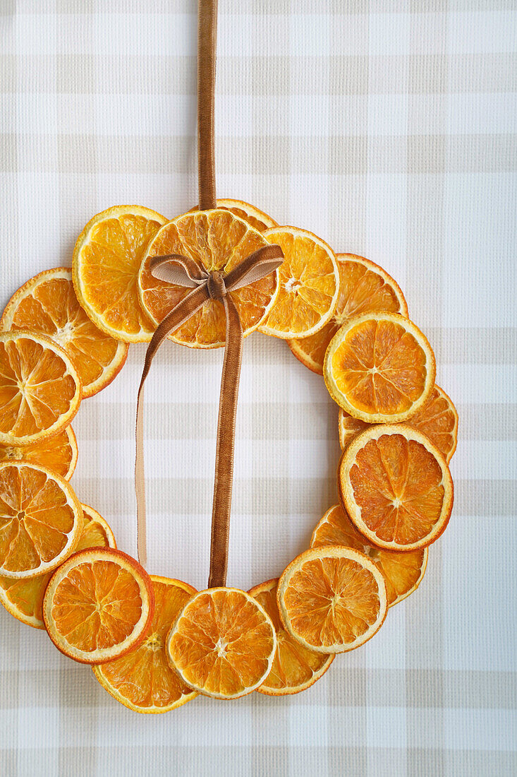 DIY door wreath made from dried orange slices on a chequered background