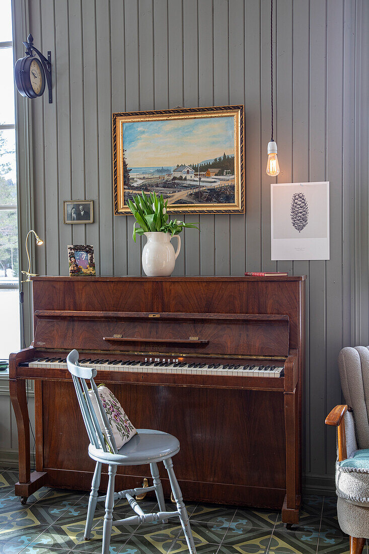 Antique piano with flower arrangement and picture frame in the living room